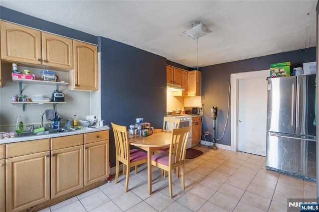 kitchen with appliances with stainless steel finishes, sink, light brown cabinets, and light tile patterned floors