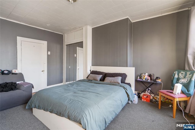 carpeted bedroom with ornamental molding and a closet