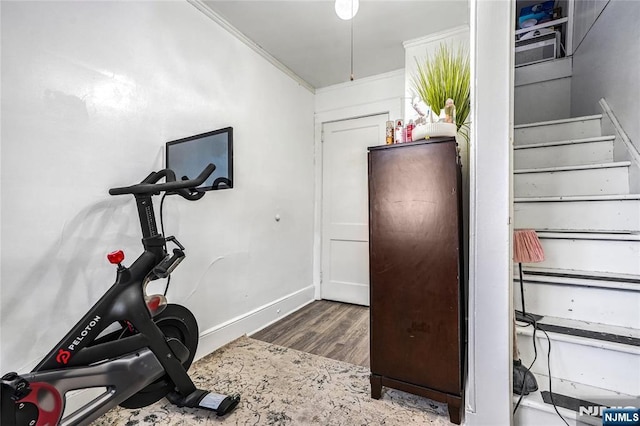 workout room with ornamental molding and dark hardwood / wood-style floors