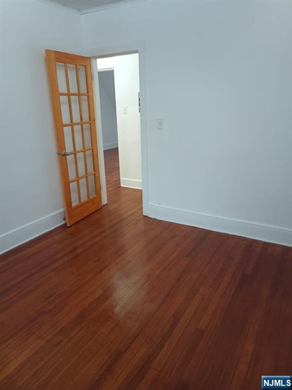 unfurnished room with dark hardwood / wood-style flooring