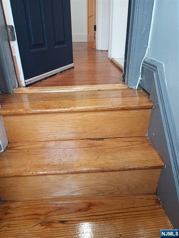 stairs featuring hardwood / wood-style floors