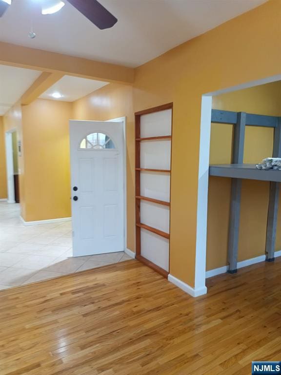 entrance foyer with beam ceiling, wood-type flooring, and ceiling fan