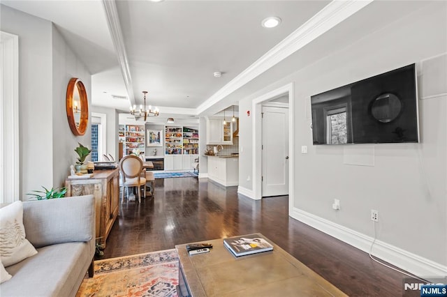 living room featuring ornamental molding, dark hardwood / wood-style floors, and an inviting chandelier