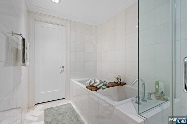 bathroom featuring tile walls, tiled tub, and crown molding