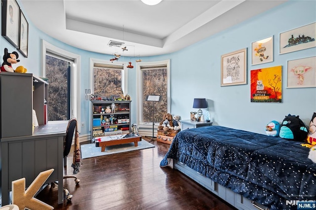 bedroom featuring dark hardwood / wood-style flooring and a tray ceiling