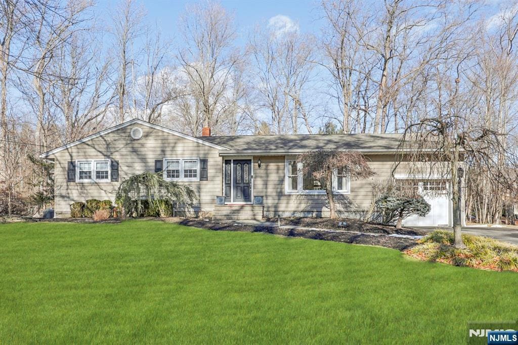 single story home featuring a garage and a front lawn