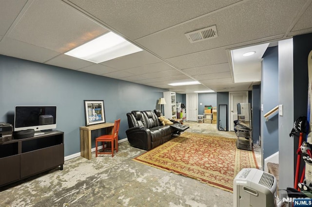 living room featuring a drop ceiling and concrete floors