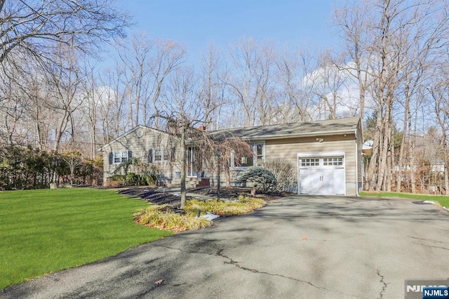 single story home featuring a garage and a front lawn