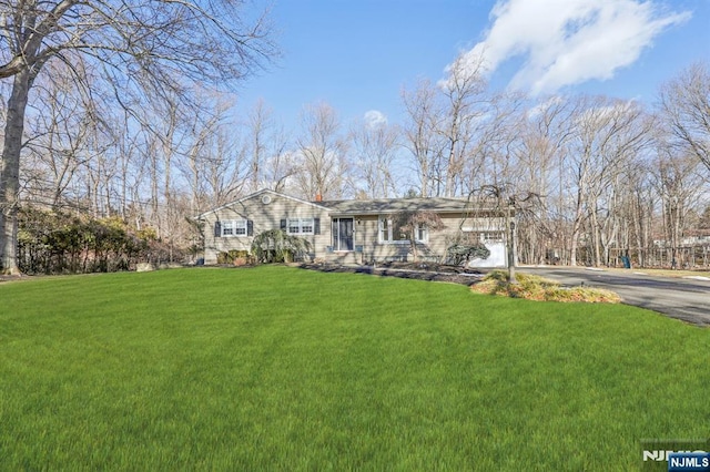 single story home with a garage and a front lawn