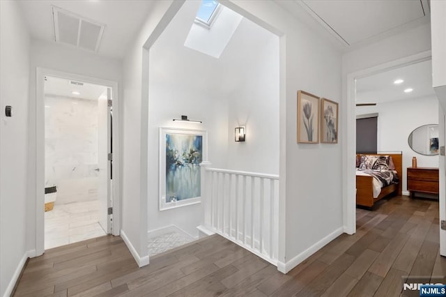 hallway with dark wood-type flooring and a skylight