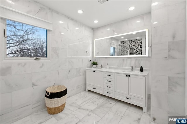 bathroom featuring vanity and tile walls