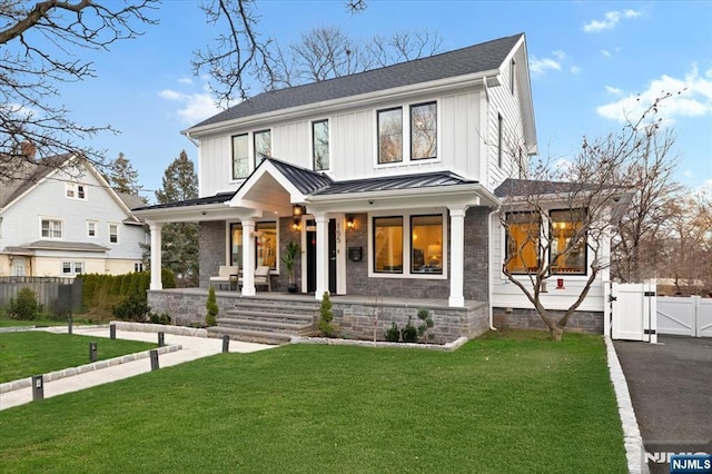 modern farmhouse style home featuring a front yard and a porch