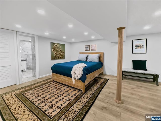 bedroom featuring ensuite bathroom and hardwood / wood-style floors