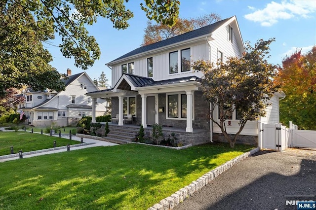 view of front of house featuring covered porch and a front lawn