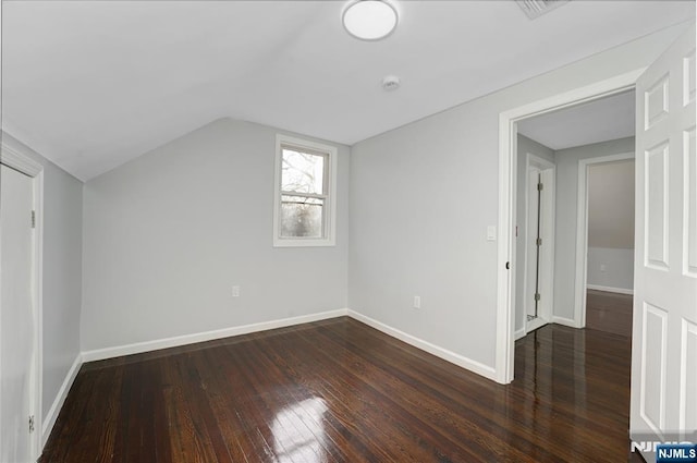 additional living space with dark hardwood / wood-style flooring and vaulted ceiling