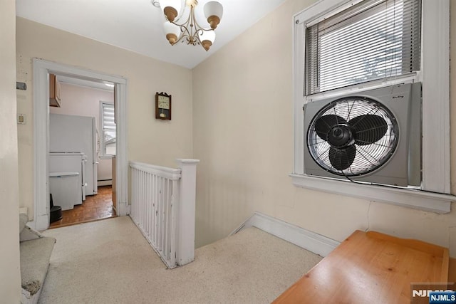 interior space featuring light carpet, a healthy amount of sunlight, ac unit, and a notable chandelier