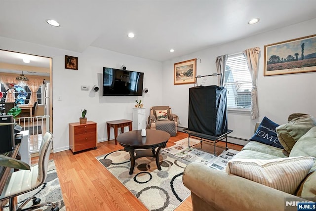 living room featuring recessed lighting, light wood finished floors, and a baseboard radiator