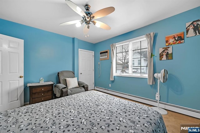 bedroom with a baseboard heating unit, a wall unit AC, and ceiling fan