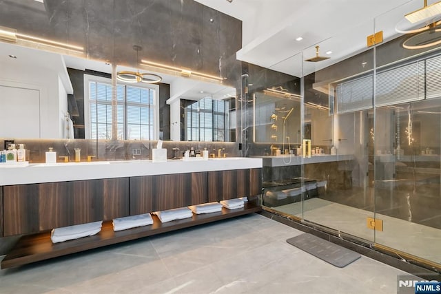 bathroom with an enclosed shower, vanity, and tile patterned flooring