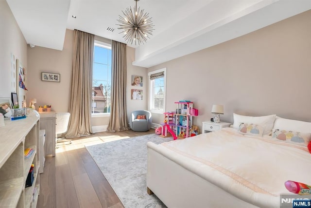 bedroom featuring a chandelier and light wood-type flooring
