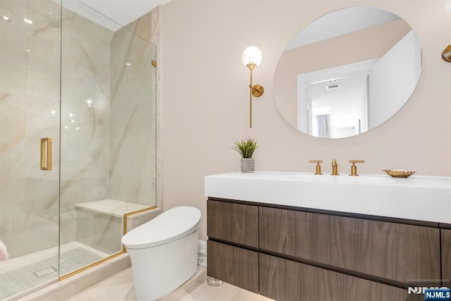 bathroom featuring a shower with door, vanity, and toilet