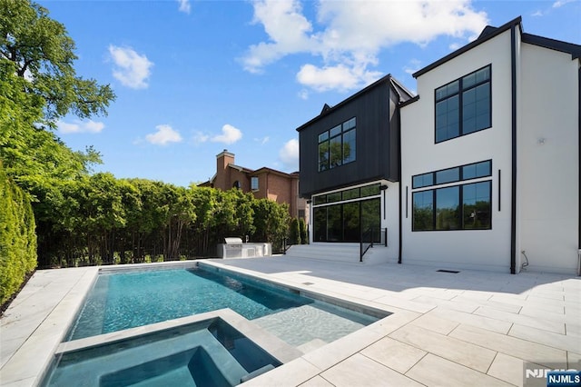 view of pool with a patio and an in ground hot tub