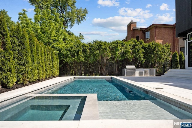 view of swimming pool with an outdoor kitchen, grilling area, and a patio