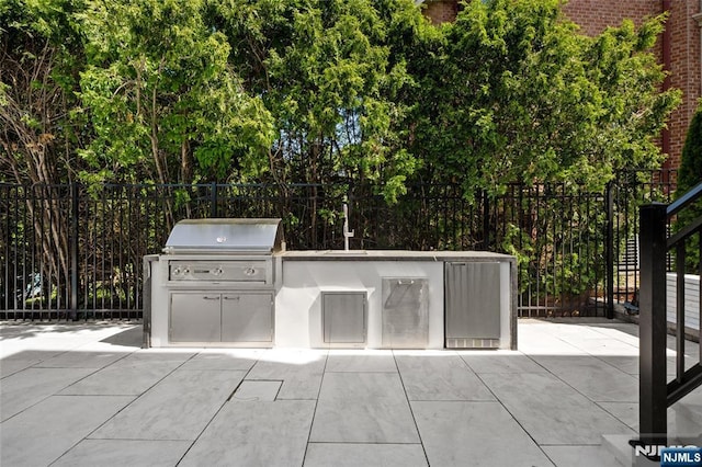 view of patio with an outdoor kitchen and a grill