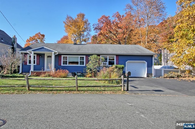 single story home with a garage and a front lawn