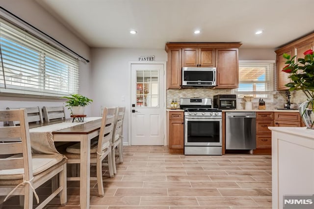 kitchen with stainless steel appliances, tasteful backsplash, and a wealth of natural light