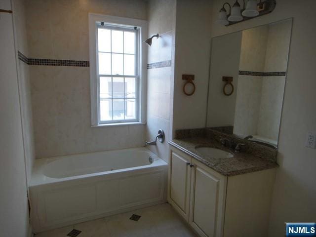 bathroom featuring a healthy amount of sunlight, shower / washtub combination, tile patterned flooring, and vanity