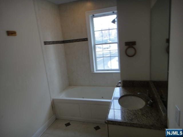 bathroom featuring vanity, a tub to relax in, and tile patterned floors