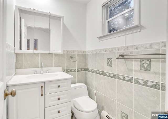 bathroom with vanity, a baseboard radiator, tile walls, and toilet