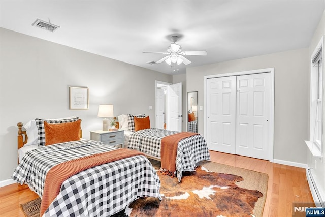 bedroom featuring ceiling fan, a closet, and light wood-type flooring