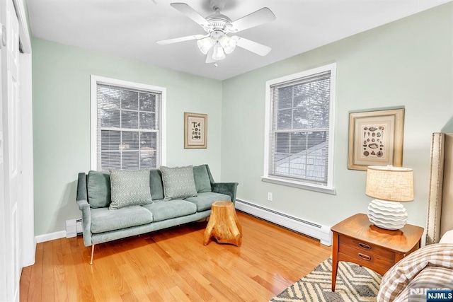 living room with hardwood / wood-style floors, a baseboard radiator, and ceiling fan