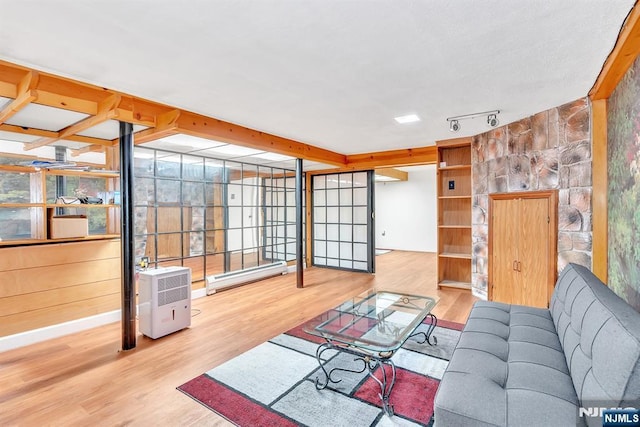 living room featuring hardwood / wood-style flooring, a baseboard radiator, and track lighting