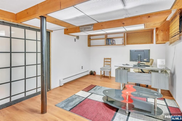 basement with a baseboard radiator and light hardwood / wood-style floors