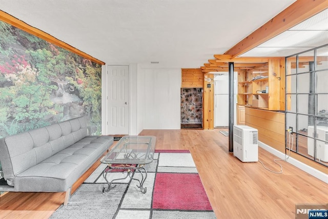 living room featuring beamed ceiling and light wood-type flooring