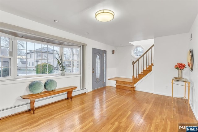 entrance foyer featuring a baseboard heating unit and wood-type flooring