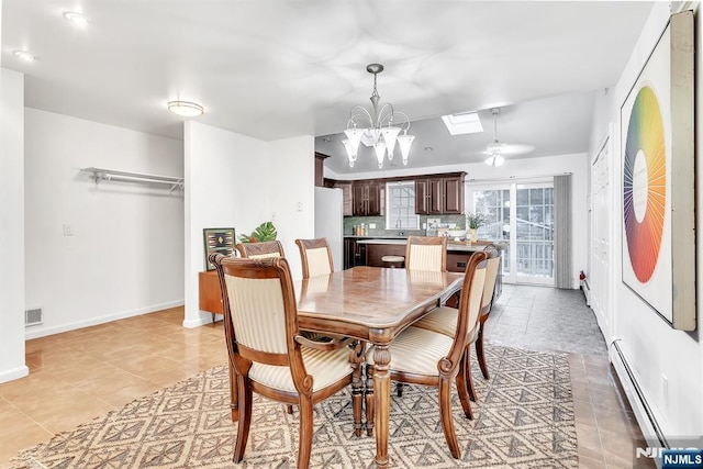 tiled dining area with a baseboard radiator, a chandelier, and a skylight