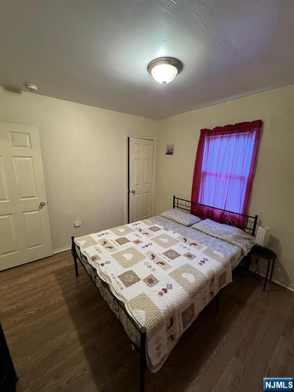 bedroom with dark wood-type flooring