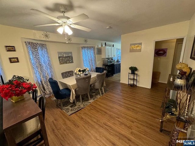 dining space with dark wood-type flooring and ceiling fan