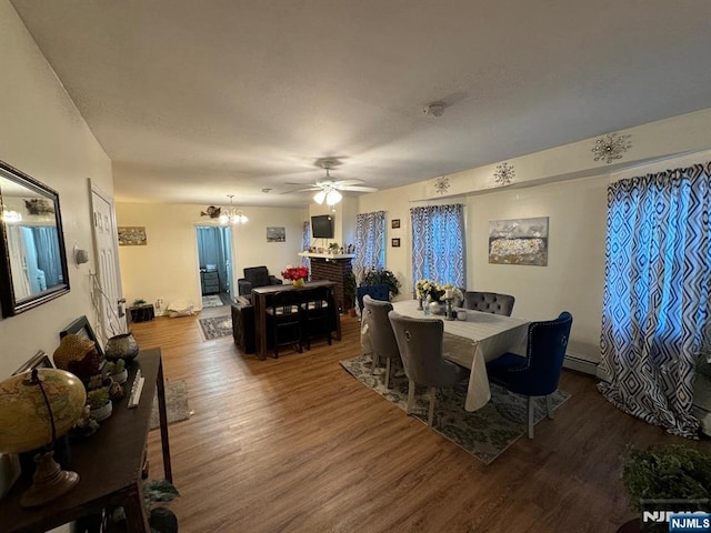 dining room with ceiling fan with notable chandelier and wood-type flooring