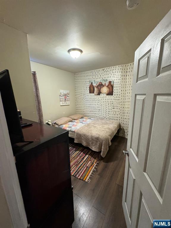 bedroom with dark hardwood / wood-style floors