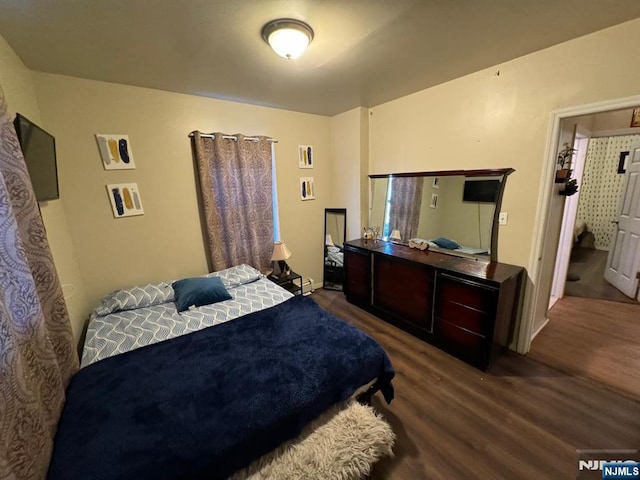 bedroom with dark wood-type flooring