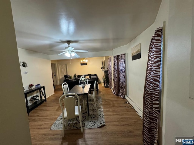 dining area featuring dark hardwood / wood-style flooring, ceiling fan, and baseboard heating