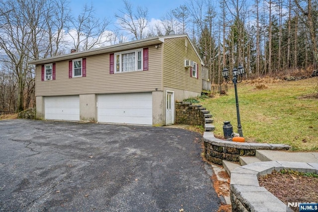 view of side of property featuring a garage and a lawn