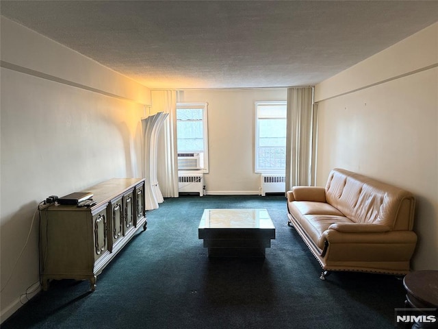 unfurnished living room featuring cooling unit, radiator, a textured ceiling, and dark colored carpet