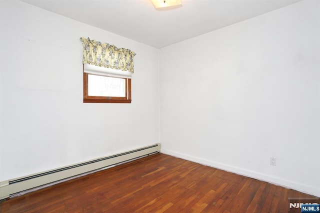 spare room with a baseboard heating unit and dark wood-type flooring