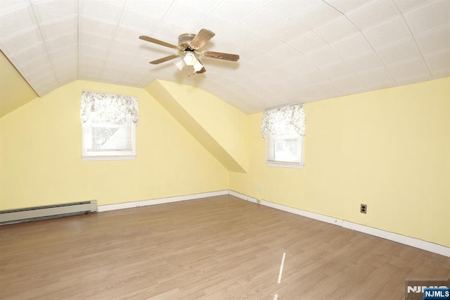 bonus room with hardwood / wood-style flooring, ceiling fan, lofted ceiling, and a baseboard heating unit